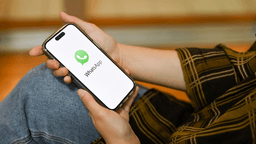 person holding cellphone with whatsapp logo on screen - monetizing whatsapp newsletter 2024